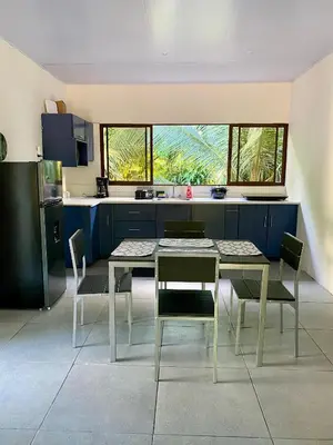 a kitchen with a table and chairs in a room at Casa El Rio in Estero