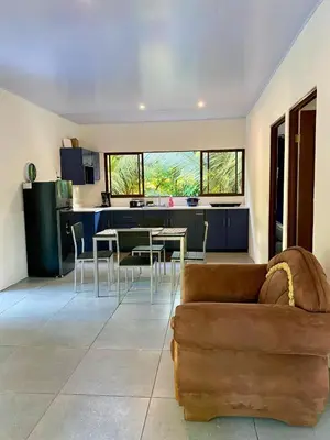 a living room with a couch and a kitchen at Casa El Rio in Estero
