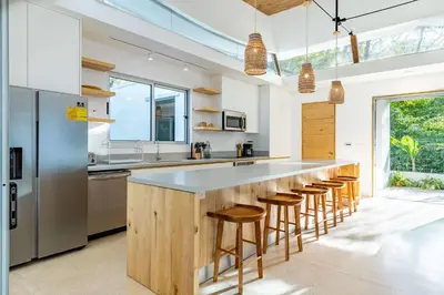 a kitchen with a large island with stools at Green House 1 in Nosara