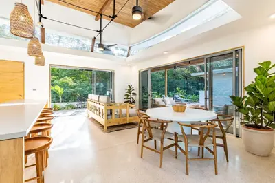 an open living room with a table and chairs at Green House 1 in Nosara
