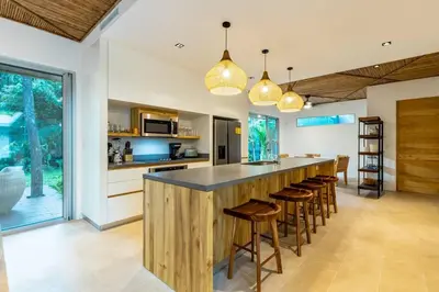 a kitchen with a counter with stools and a bar at Green House 2 in Nicoya