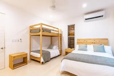 a bedroom with two beds and a bunk bed at Green House 2 in Nicoya