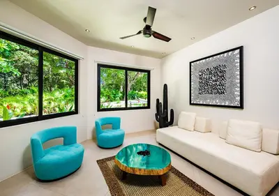 a living room with a white couch and blue chairs at Xanadu Luxury Villa 5BR - 10P Tamarindo - Hacienda Pinilla in Tamarindo