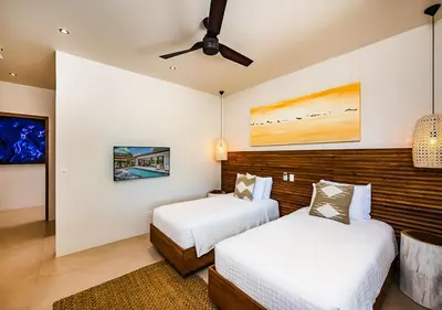 a bedroom with two beds and a ceiling fan at Xanadu Luxury Villa 5BR - 10P Tamarindo - Hacienda Pinilla in Tamarindo