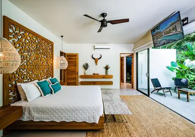 a bedroom with a bed and a ceiling fan at Xanadu Luxury Villa 5BR - 10P Tamarindo - Hacienda Pinilla in Tamarindo