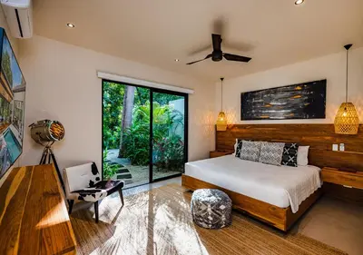 a bedroom with a bed and a large window at Xanadu Luxury Villa 5BR - 10P Tamarindo - Hacienda Pinilla in Tamarindo