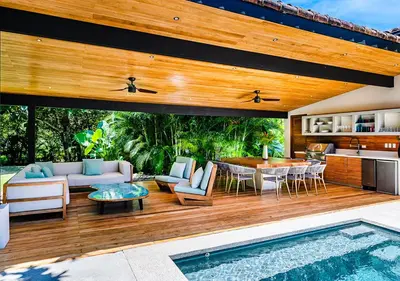 an outdoor patio with a table and a pool at Xanadu Luxury Villa 5BR - 10P Tamarindo - Hacienda Pinilla in Tamarindo