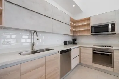 a kitchen with wooden cabinets and a stainless steel sink at Sophisticated Home with a Chic Design and a Private Terrace with a Plunge Pool in Artola
