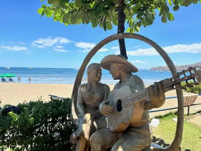 a statue of two men playing a guitar on the beach at Sophisticated Home with a Chic Design and a Private Terrace with a Plunge Pool in Artola