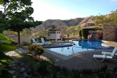 a swimming pool with two chairs and a house at Sophisticated Home with a Chic Design and a Private Terrace with a Plunge Pool in Artola