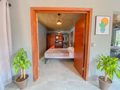a bedroom with a bed and two potted plants at Casitas la Esquina in Monteverde Costa Rica