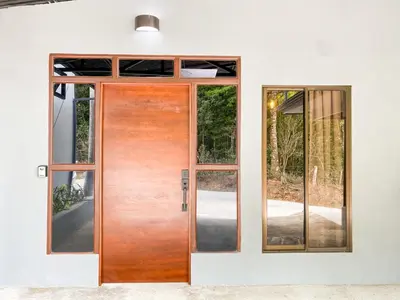 a wooden door in a house with windows at Casitas la Esquina in Monteverde Costa Rica
