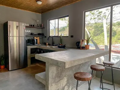 a kitchen with a large counter and a refrigerator at Casitas la Esquina in Monteverde Costa Rica