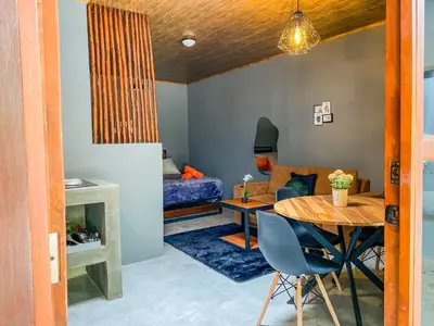 a living room with a table and a bedroom at Casitas la Esquina in Monteverde Costa Rica
