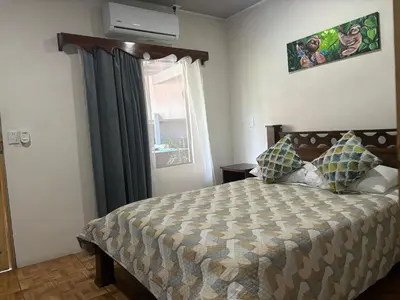 a bedroom with a large bed and a window at Casa veranera in Quepos