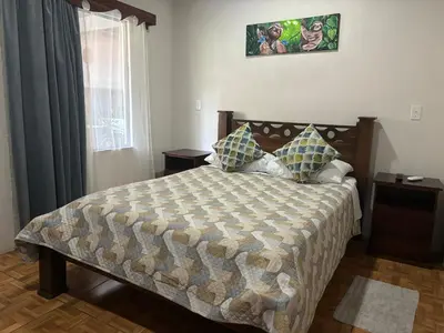 a bedroom with a large bed and a window at Casa veranera in Quepos