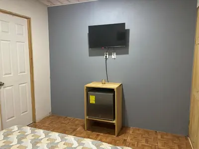 a bedroom with a bed and a tv on a wall at Casa veranera in Quepos