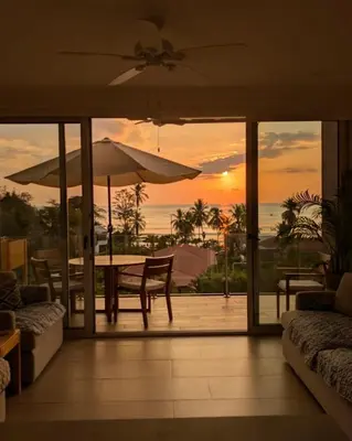 a living room with a table and an umbrella at Beachfront Condo Stunning Views in Jacó