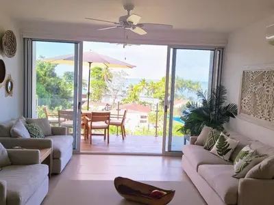 a living room with a couch and a table with an umbrella at Beachfront Condo Stunning Views in Jacó
