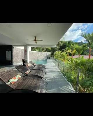a house with a ceiling fan and a swimming pool at Beachfront Condo Stunning Views in Jacó
