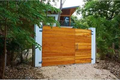 a wooden gate in front of a house at Casa Canopy in Nosara