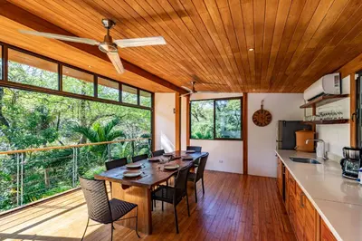 a kitchen and dining room with a wooden ceiling at Casa Canopy in Nosara