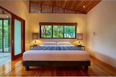 a bedroom with a large bed with two lamps at Casa Canopy in Nosara