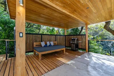 a porch with a bench on a wooden deck at Casa Canopy in Nosara