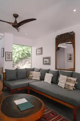 a living room with a couch and a mirror at Casa Coastin in Nosara