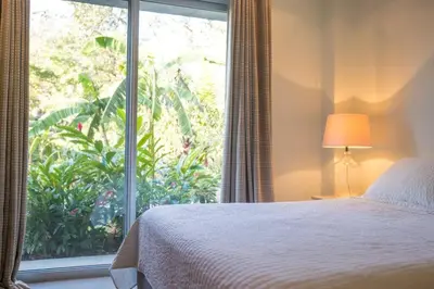 a bedroom with a bed and a large window at Casa Coastin in Nosara