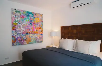 a bedroom with a bed and a painting on the wall at Casa Coastin in Nosara