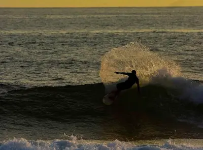 a man riding a wave on a surfboard in the ocean at Casa Coastin in Nosara
