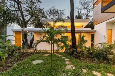 a house with a palm tree in front of it at Green house 1&2 Green Complex in Nosara