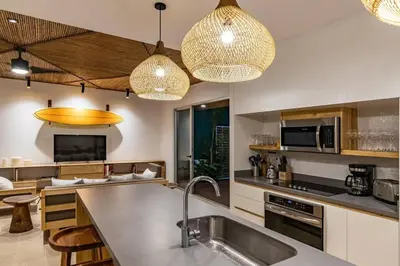a kitchen with two pendant lights above a sink at Green house 1&2 Green Complex in Nosara
