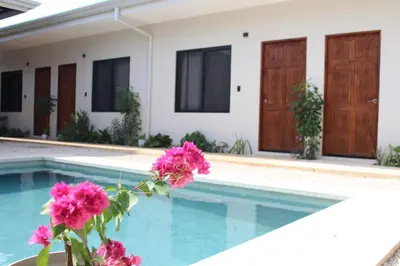a villa with a swimming pool and pink flowers at Hotel Huacas in Huacas