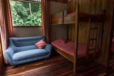 a bunk bed and a couch in a room at Cala Lodge in Monteverde Costa Rica