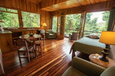 a bedroom with a bed and a table and chairs at Cala Lodge in Monteverde Costa Rica