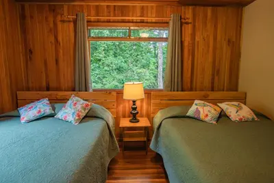 two twin beds in a room with a window at Cala Lodge in Monteverde Costa Rica