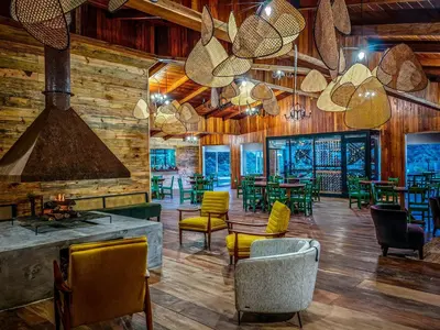 a restaurant with wooden walls and chairs and tables at Cloud Forest Lodge in Monteverde Costa Rica