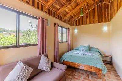 a small room with a bed and a couch at Monteverde Villa Lodge in Monteverde Costa Rica