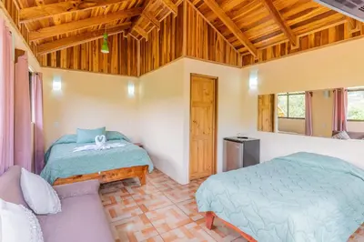 a bedroom with two beds and a couch at Monteverde Villa Lodge in Monteverde Costa Rica