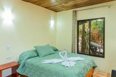 a bedroom with a green bed with towels on it at Monteverde Villa Lodge in Monteverde Costa Rica