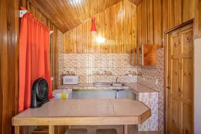 a kitchen with a table and a sink and wooden walls at Monteverde Villa Lodge in Monteverde Costa Rica