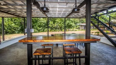 a large wooden table in a room with chairs at Casa Del Oeste, Playa Avellanas Beach House in Playa Avellana