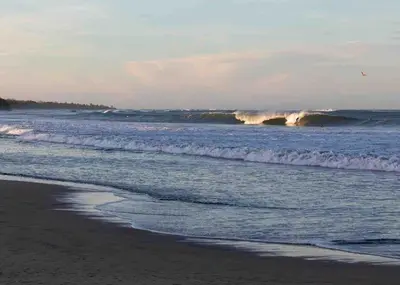 a wave in the ocean on a beach at Casa Del Oeste, Playa Avellanas Beach House in Playa Avellana