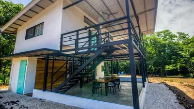a house with a staircase leading up to a patio at Casa Del Oeste, Playa Avellanas Beach House in Playa Avellana