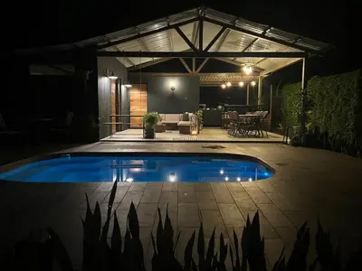 a swimming pool in the middle of a patio at night at Alojamiento con piscina in Aguas Zarcas