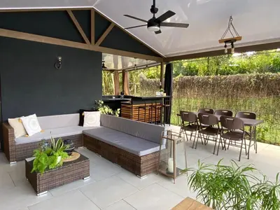 a patio with a couch and chairs and a table at Alojamiento con piscina in Aguas Zarcas