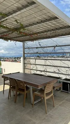 a wooden table and chairs on a patio at Modern, large and equipped in San José