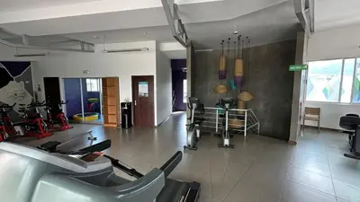 a room with a gym with chairs and a table at Modern, large and equipped in San José